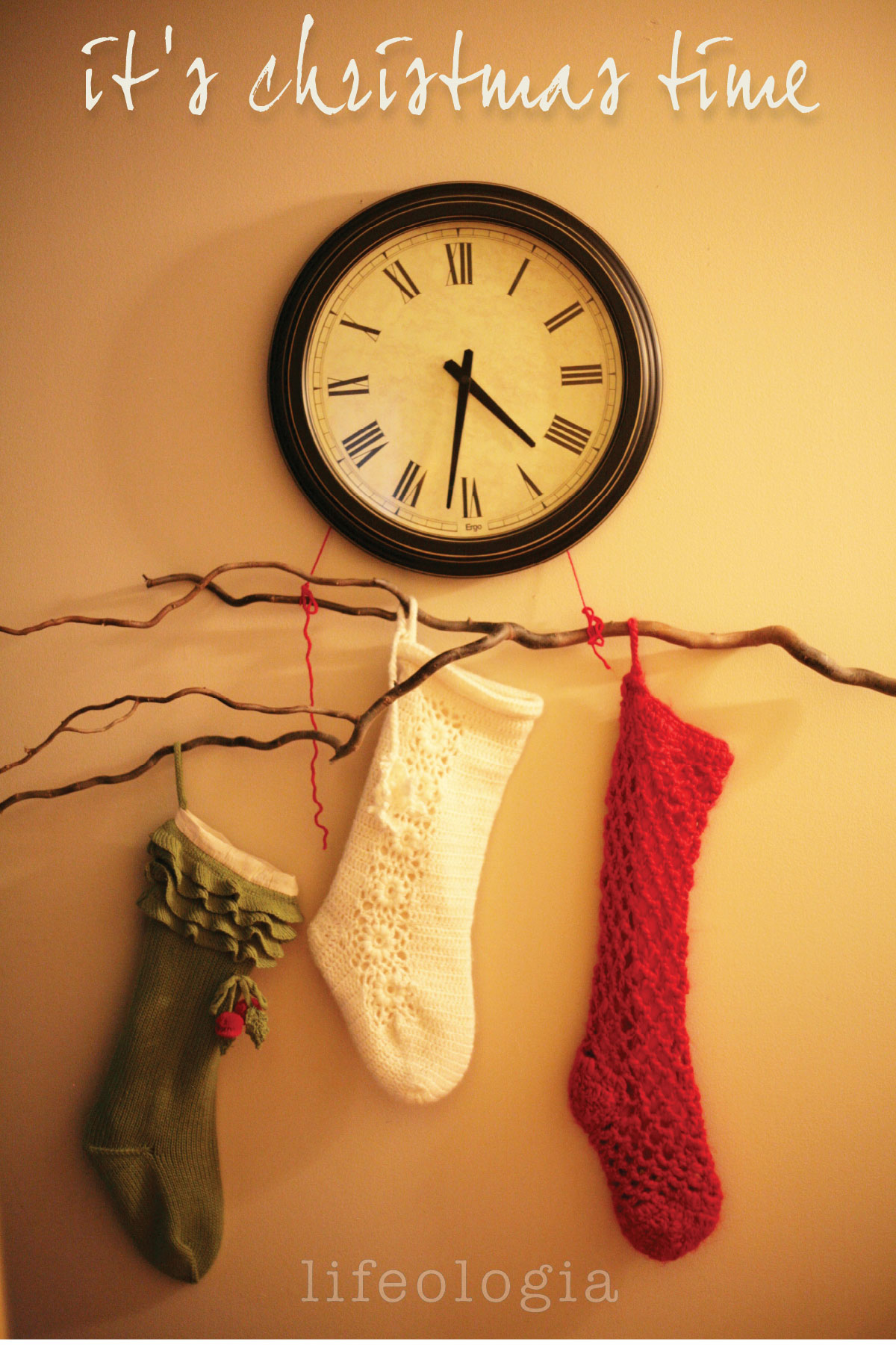 christmas-decorating branch with stockings hung from a clock